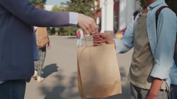 Tussenschot Van Onherkenbare Moeder Die Lunchtas Overhandigt Aan Aziatische Jarige — Stockvideo