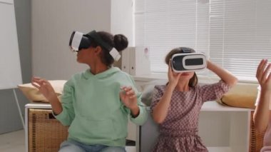 İki liseli kızın VR gözlük takıp ders sırasında sınıfa bakınırken çekilmiş fotoğrafları.