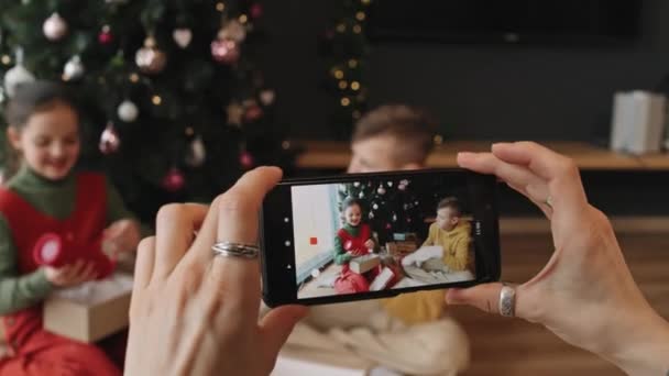 Nerozpoznatelné Ženské Ruce Drží Smartphone Nahrávání Videa Dvou Veselých Sourozenců — Stock video