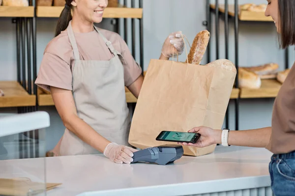 Joyeux employé de boulangerie vendant du pain — Photo