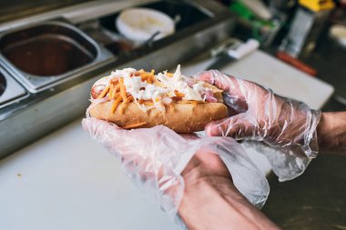 Eldivenli genç adam taze fast food tutuyor.