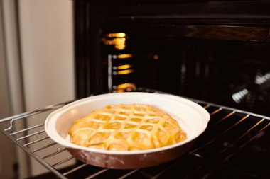 Elektrikli fırının çubuklarında duran fırın şeklinde taze elmalı turta.