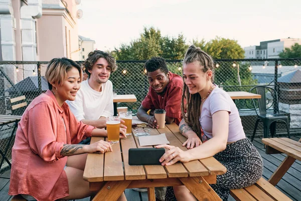 Felices amigos multirraciales que se comunican en el chat de vídeo en la cafetería al aire libre —  Fotos de Stock