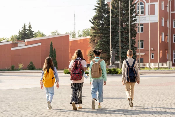 Grupo de alunos com mochilas indo para a escola pela manhã — Fotografia de Stock