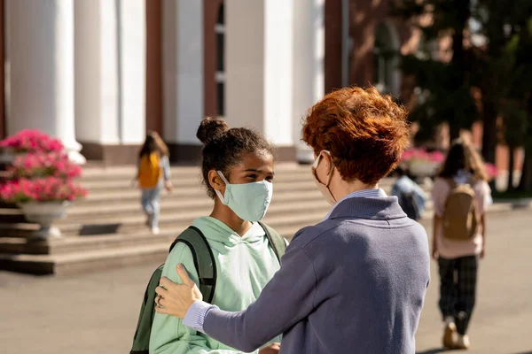 Joven alumna y alumna de secundaria con máscaras protectoras —  Fotos de Stock