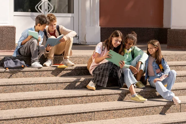 Groep adolescente schoolkinderen die tabletten gebruiken terwijl ze op de trap zitten — Stockfoto
