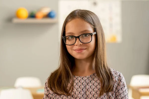 Cute secondary school pupil in eyeglasses looking at camera — Stock Photo, Image