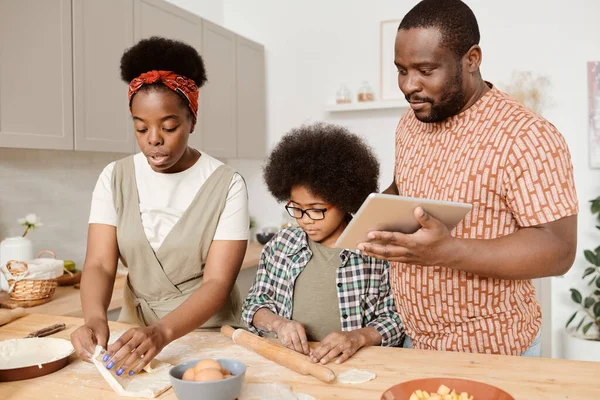 Ung afrikansk familj av tre matlagning hembakat bakverk — Stockfoto