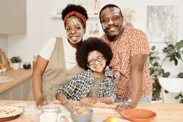 Alegre y divertida familia africana de tres de pie por la mesa de la cocina —  Fotos de Stock