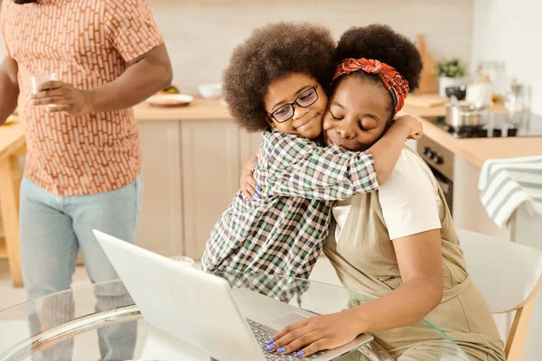 Söt liten pojke omfamna sin mamma nätverk framför laptop — Stockfoto