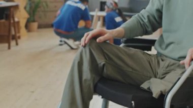 Tekerlekli sandalyede maluliyeti olan tanınmayan bir adamı, gönüllü grubun kadın üyeleriyle el sıkışırken yakına getir. Gönüllüler evdeki mobilyaların montajı veya onarımı için yardım etmeye geldiler.