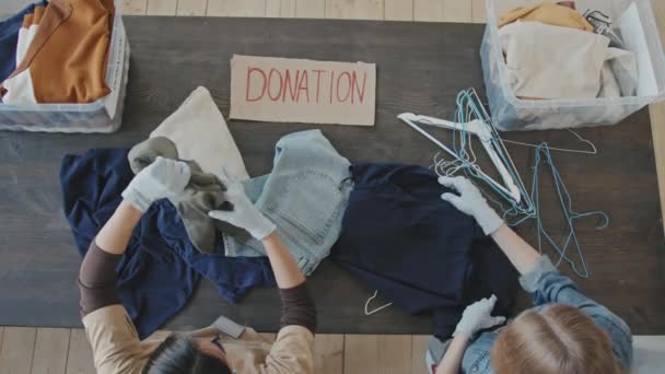 Медленная Съемка Двух Женщин Волонтёров Которые Сортируют Пожертвованную Одежду Перед — стоковое видео