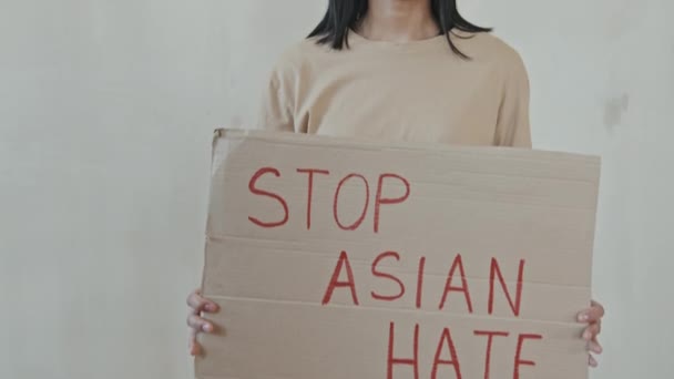 Przechyl Się Portret Młodej Poważnej Azjatki Patrząc Kamerę Trzymającą Karton — Wideo stockowe