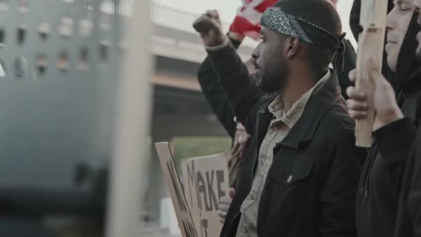 用盾牌在防暴警察面前高喊和抗议的一群年轻人的慢镜头 — 图库视频影像