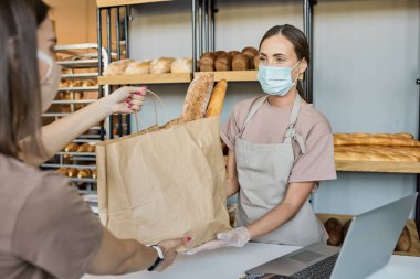 Güzel fırın işçisi bir torba dolusu ekmek veriyor.