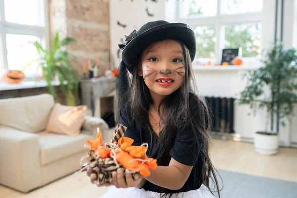 Linda chica asiática con un montón de dulces en las manos — Foto de Stock