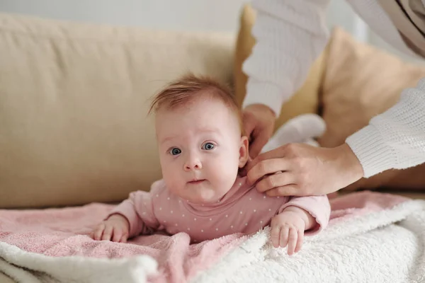 Linda niña en chaqueta suelta rosa tumbada en el sofá —  Fotos de Stock