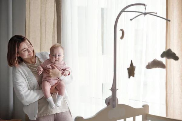 Jonge vrouw houden haar schattig dochtertje en kijken naar haar — Stockfoto