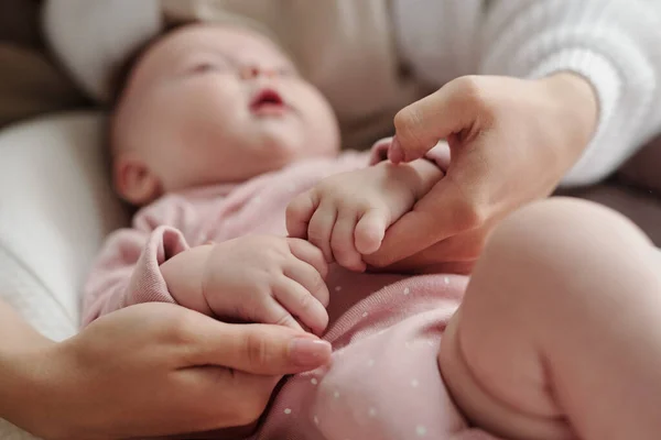 Händer unga mor lugnande baby ner medan vaggning henne — Stockfoto