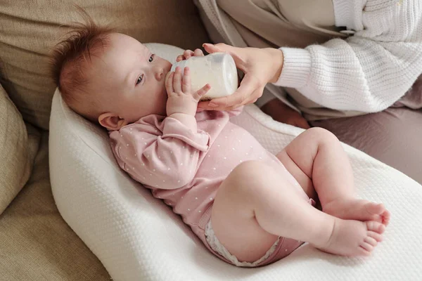 Annemin tuttuğu şişeden süt yiyen tatlı bebek. — Stok fotoğraf