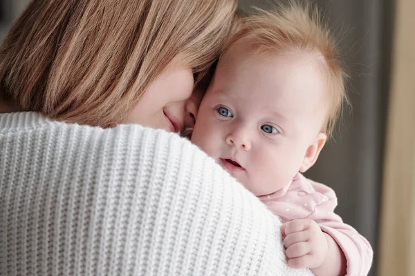 Face of adorable baby girl on hands of her affectionate mother — Stock Photo, Image