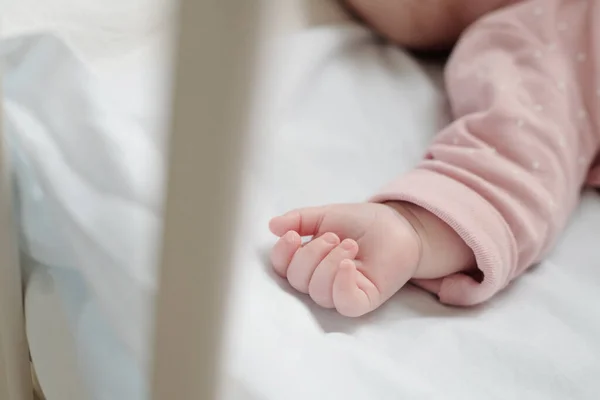 Pequeña mano de lindo bebé en rosa bebé chaqueta suelta — Foto de Stock