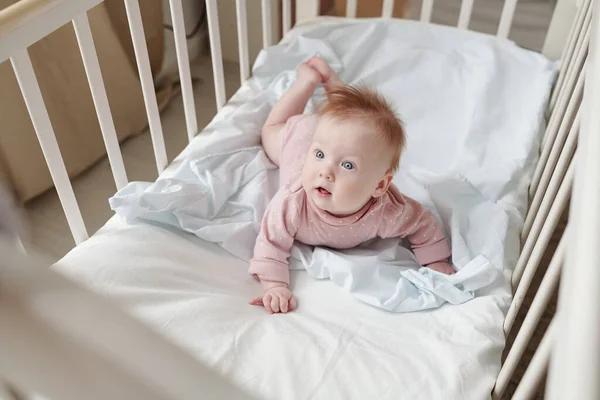 Klein schattig in roze kleren kijken aandachtig naar iets — Stockfoto