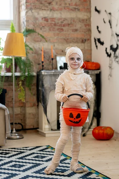 Kleine mummie met pompoenemmer voor lekkernijen — Stockfoto