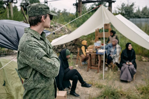 Солдат охороняє біженців у таборі — стокове фото