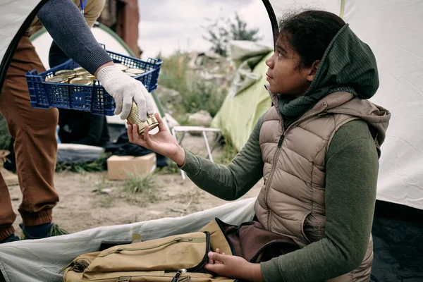 Dawanie puszek żywności dla dziewczyny uchodźców — Zdjęcie stockowe