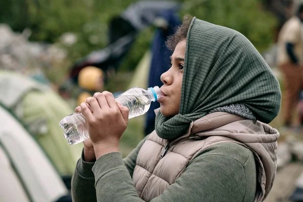 Migrante ragazza acqua potabile — Foto Stock