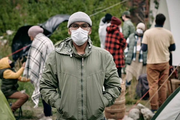 Homme en masque contre la foule de migrants — Photo