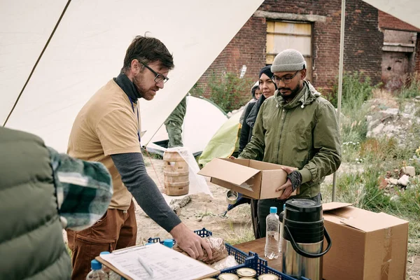 Önkéntes ételt ad a menekülteknek — Stock Fotó