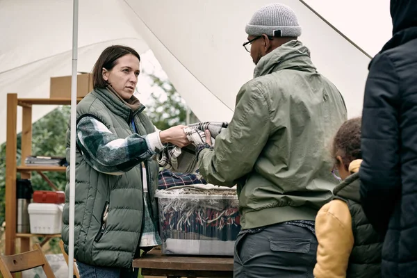 Maatschappelijk werker verstrekken van warme ruiten aan vluchtelingen — Stockfoto