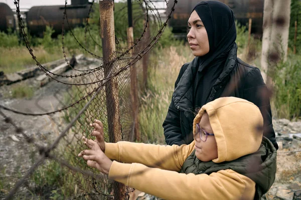 鉄条網で子供とイスラム教徒の女性 — ストック写真