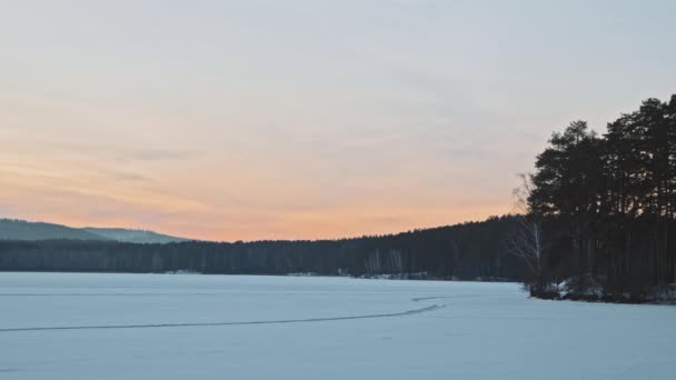 Soğuk Kış Akşamında Kar Ormanla Kaplı Donmuş Gölün Pan Yavaşlığı — Stok video