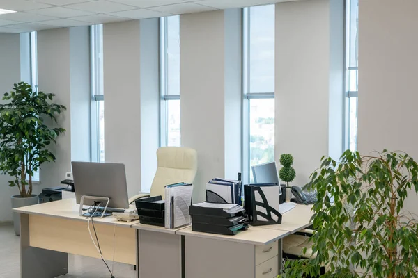 Paire de bureaux avec moniteurs d'ordinateur et documents debout le long des fenêtres — Photo