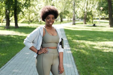 Parkta duran genç ve iri yarı sporcu kadın.