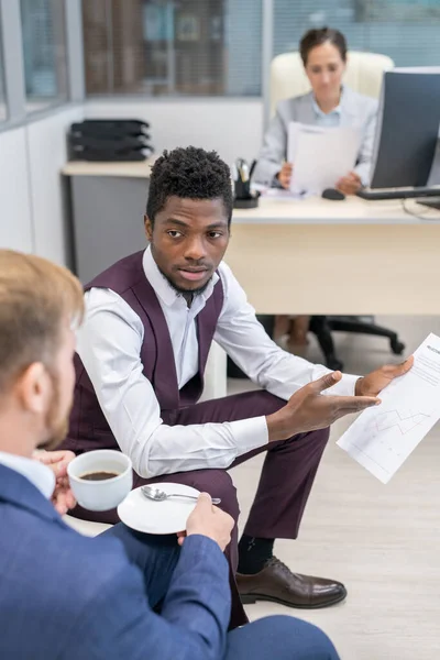 Joven empresario africano discutiendo el papel con su colega — Foto de Stock