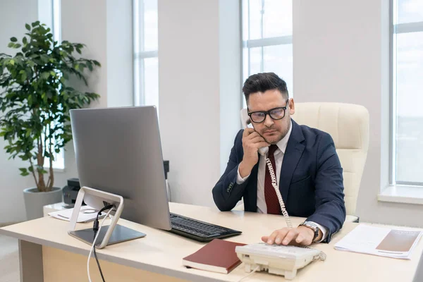 Mature businessman dialing phone number by his workplace — Stock Photo, Image