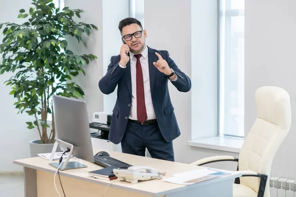 Confident employer in elegant suit discussing terms of deal on telephone — Stock Photo, Image