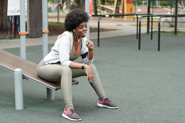 Junge erholsame Sportlerin kommuniziert im Freien — Stockfoto