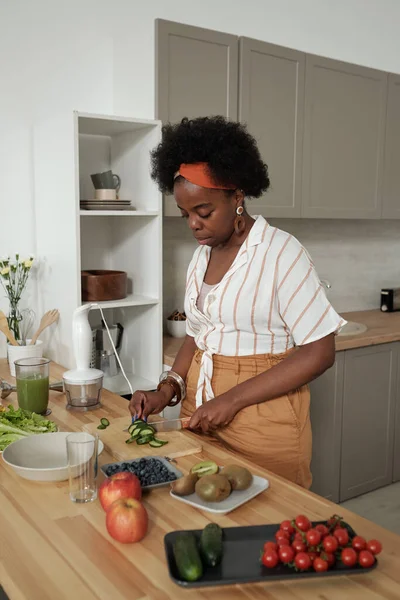 Jeune femme au foyer cuisine salade de légumes dans la cuisine — Photo