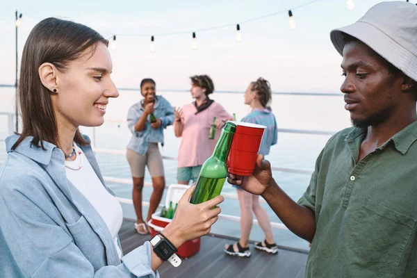 Jóvenes citas interculturales tintineo con bebidas contra sus amigos —  Fotos de Stock