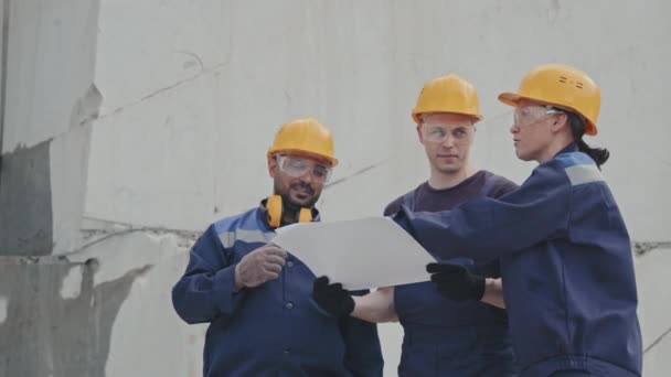 Pomalý Střední Záběr Mužských Ženských Dělnic Uniformách Tvrdých Kloboucích Diskutujících — Stock video