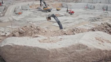 Granit ocağında çalışan çeşitli ağır makinelerin izini sürüyorum.