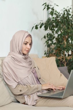 Dizüstü bilgisayarda çalışan Müslüman kadın