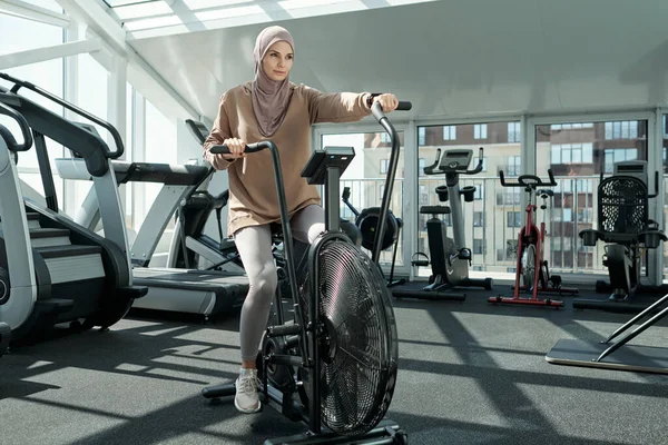Mujer usando bicicleta estacionaria —  Fotos de Stock