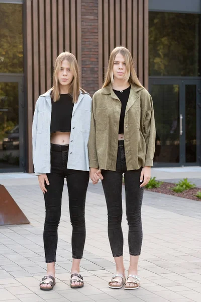 금발의 쌍동 이 소녀 둘 이 평상복 차림으로 거리에 서 있다 — 스톡 사진