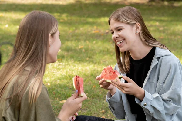 Deux adolescentes mignonnes ayant pastèque tout en se relaxant dans le parc — Photo